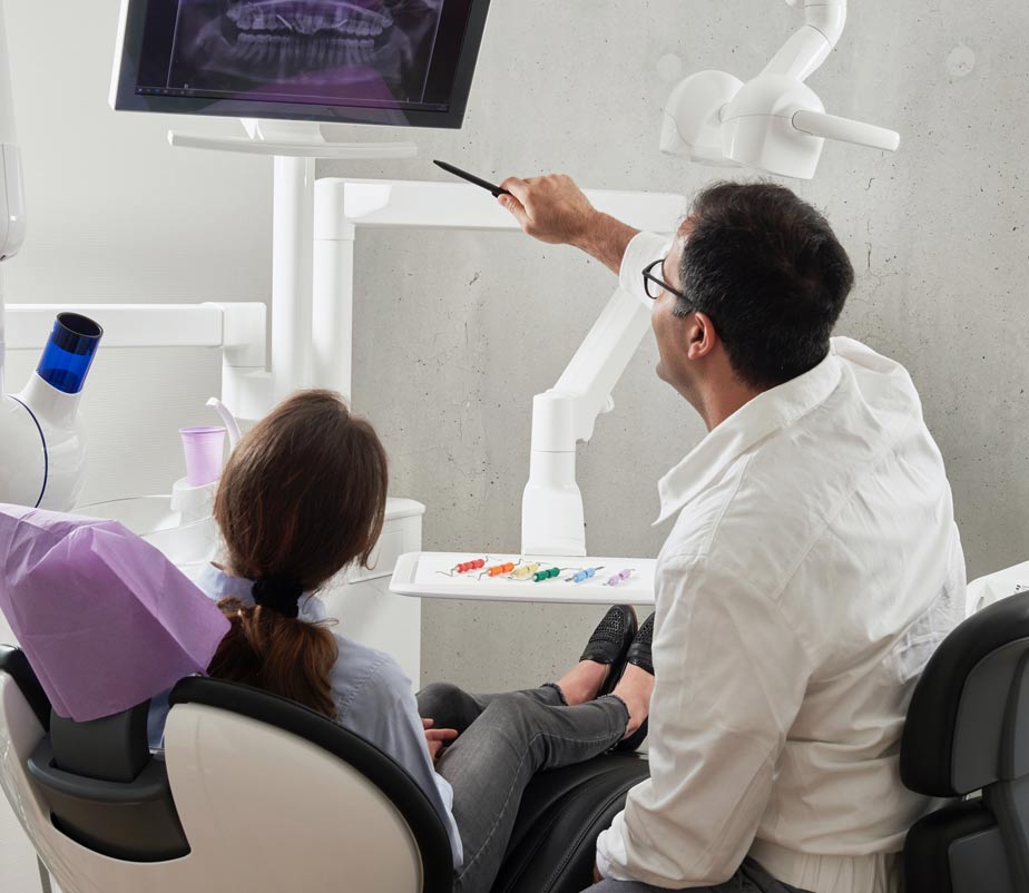 Dentist pointing at chart, person watching