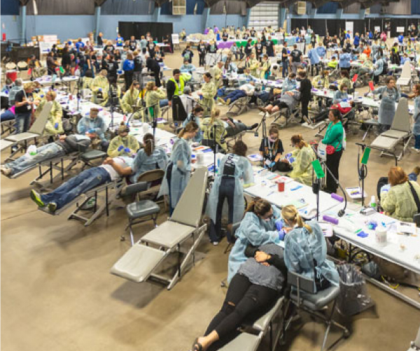 Employees in a large room providing dental services.