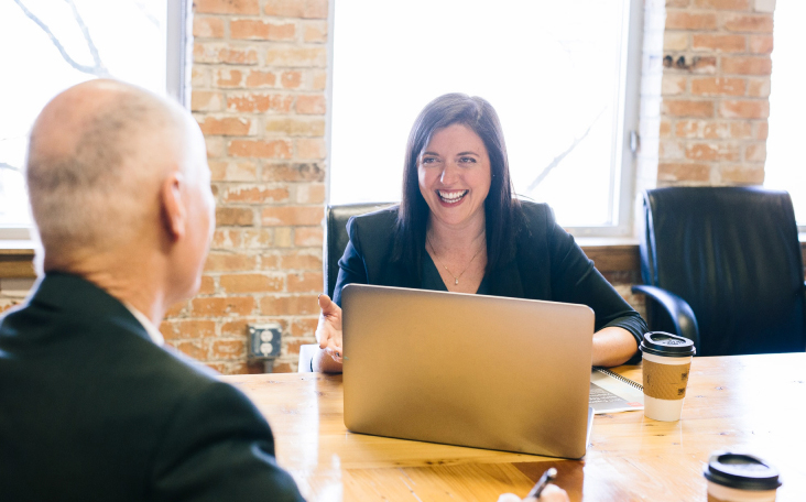 Woman at a conference table with a computer