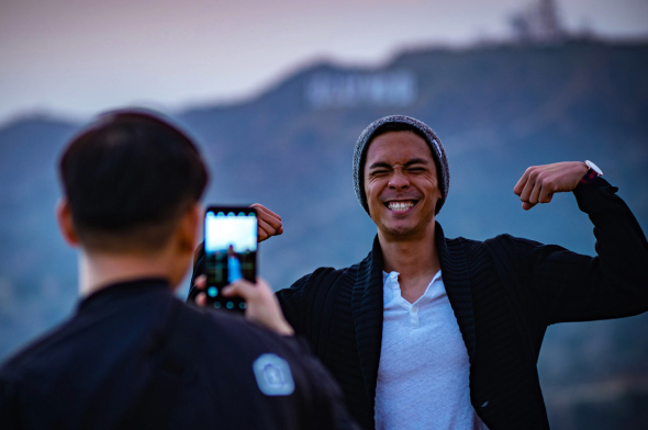 Man smiling for photo in front of a mountain